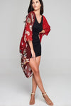 Model wearing red chiffon kimono with floral prints facing right